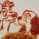 A portrait of a scene from "Lady and the Tramp" rendered in spaghetti and sauce